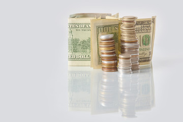 Packs of coins and dollar bills on a glass table. Business concept