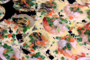 Obraz na płótnie Canvas Thai-style takoyaki with mussels sea food shrimp and squid, Mini fried mussels in batter, Fried mussels mini pancake, Mini pancake with mussels, Pan Fried Seafood Omelette, Hoi Tod Krob (Thai Word)