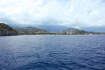 Calm Mediterranean Sea and mountains with green trees in Antalya