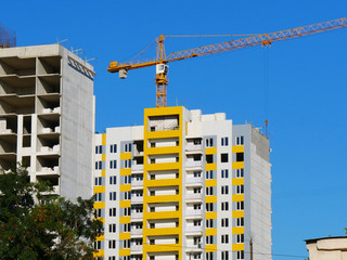Crane near building under construction. Construction site.