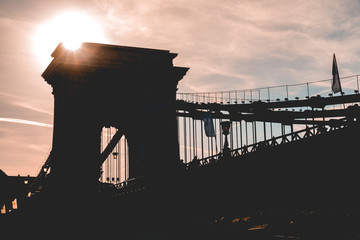 Naklejka premium silhouette of chain bridge at budapest with small sunlight on the top