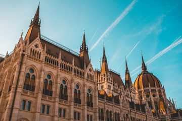 Fototapeta premium low angle view of parliament building at budapest with big contrails in the sky