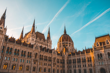 beautiful parliament building of hungary with two contrails in the sky