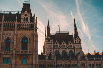 Obraz premium darken rooftop of parliament building at budapest with contrails in the sky