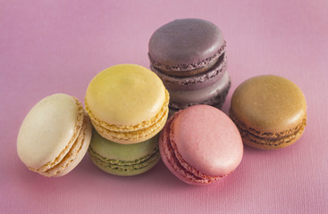 Fototapeta na wymiar A Variety of French Macarons Flavors on a Pink Background