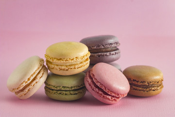 Obraz na płótnie Canvas A Variety of French Macarons Flavors on a Pink Background
