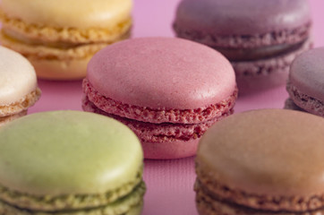 Fototapeta na wymiar A Variety of French Macarons Flavors on a Pink Background