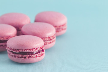 Obraz na płótnie Canvas Pink French Macarons on a Blue Background