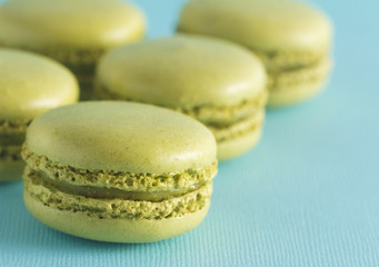 Green French Macarons on a Blue Background