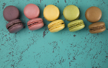 A Variety of French Macarons Flavors on a Textured Turquoise Background