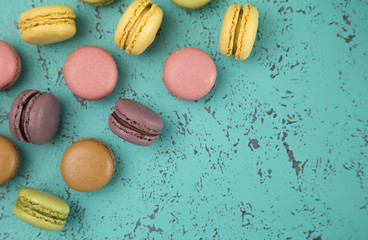 A Variety of French Macarons Flavors on a Textured Turquoise Background
