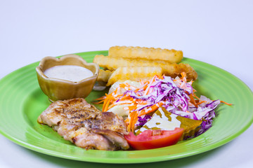 pork steak and vegetable served on  white dish with white background