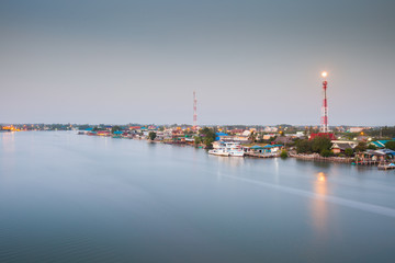 Fisherman village beside river with moon reflection in early morning located thai gulf of thailand