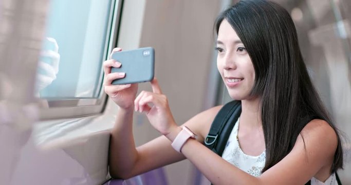 Woman taking photo with cellphone on Taipei city metro