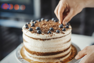 Young attractive man decorating cake