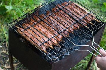 Lulya kebab from meat are prepared in the grill. Shish kebab in the grill.