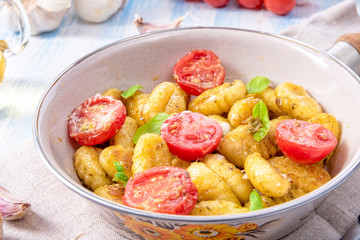 gnocchi baked with green pesto, cherry tomatoes and parmesan