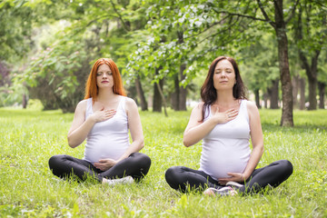 Obraz premium Pregnant young women doing prenatal yoga.