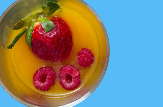 high view of non-alcoholic cocktail with strawberry and raspberry juice with light blue background