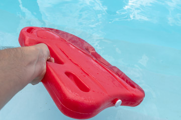 Schwimmhilfe im Wasser - Rotes Schwimmbrett