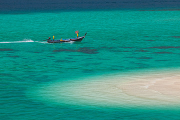 White sand beach beach and long tail boat is floating on sea at ocean in Tropicana located at south of thailand 