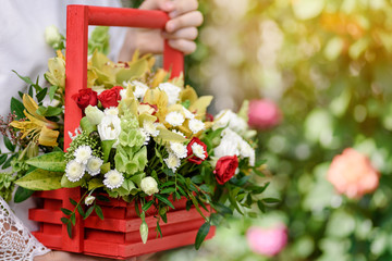 A girl holding a beautiful composition of flowers in her hands