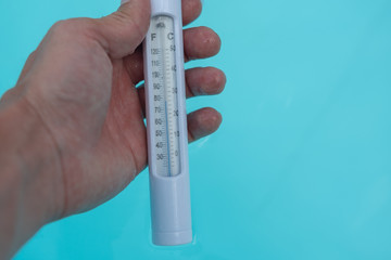 Thermometer in der Hand vor Wasser
