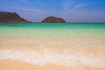 Fototapeta na wymiar White sand beach with moutain under clear sky at ocean in Tropicana located at south of Thailand 