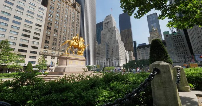 An extreme wide angle establishing shot of the William Tecumseh Sherman Monument near Central Park with the Manhattan skyline in the background.  	