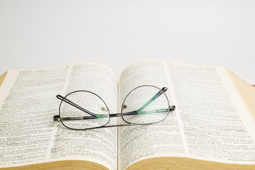 Glasses on open book with white background