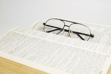 Glasses on open book with white background