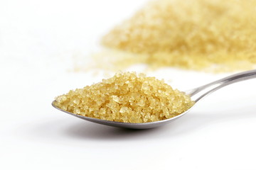 Sugar in spoon, Sugar brown heap from sugar cane on spoon stainless steel and background granulated sugar yellow