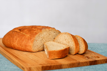 Rye fresh bread, fresh bread on the table in the dark interior. With brain Bread cut into place on the cutting Board. Crisp fresh crust. Enjoy your meal.