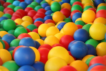 Children's party, toys – a lot of colorful plastic balls in a dry pool: red, green, blue, yellow.
