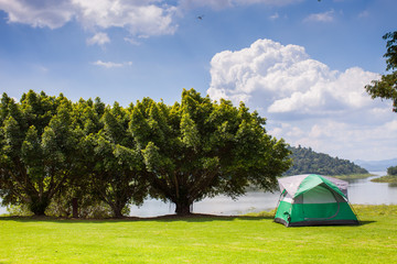Camping tent on green grass field under clear sky 