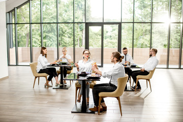 Business people having lunch with delicious meals sitting in pairs at the modern restaurant