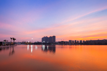 Fototapeta premium Reflection of condominium on water surface at sunset timing located at impact arina Bangkok Thailand 