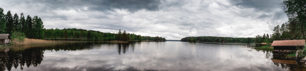 Fototapeta na wymiar Panorama von einem See in Finnland in Lappland mit dunklen Wolken