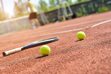 Close up view of tennis racket and balls on the clay tennis court