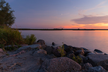Obraz premium Rocky shore of the sea bay in the quiet evening