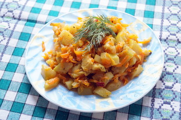 Vegetarian dish of mixed vegetables, Asian and Indian recipe, zucchini, carrots, onions, potatoes, hot and spicy, served in a bowl with a checkered napkin