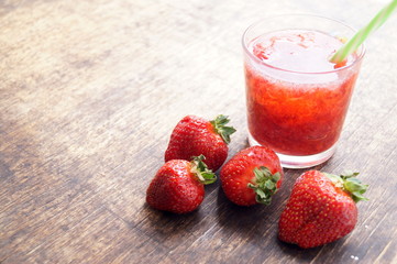 Sweet fresh strawberry juice, smoothies on the wooden table, selective focus