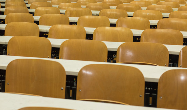 Sedie ordinate simmetricamente in aula universitaria. Scuola vuota. Banchi, sedie