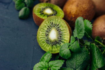 fresh kiwi fruit with mint on black background