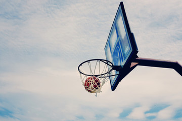 Basketball hoop with ball in net, shooting around for sport game practice.