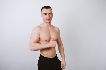 Young Sportsman smiling at the camera with thumb up. Good offer, training, gym, workout.
