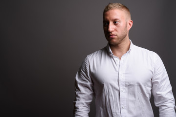 Businessman with blond hair against gray background