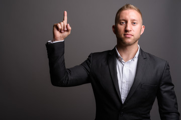 Businessman with blond hair against gray background