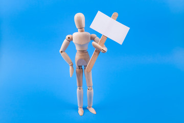 Wooden manikin figure holding a blank picket sign