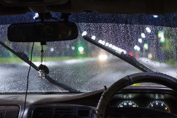 beautiful drops of water on the windshield of the car with the glass cleaners turned on, during a...